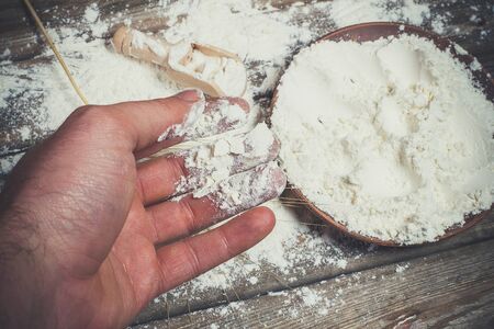 Flour and spikelets of wheat for baking bread lies on a wooden brown surfaceの写真素材