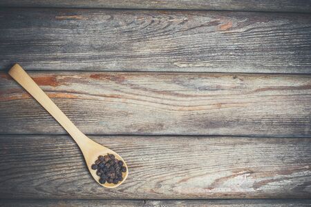 Different spices and salt lie in wooden spoons on a wooden brown tableの写真素材