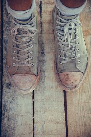 Green old sneakers on a man's footの写真素材