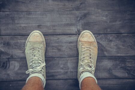 Green old sneakers on a man's footの写真素材