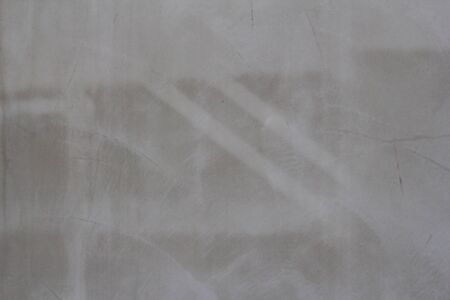 Gray concrete wall texture with scratches and cracks on it.の写真素材