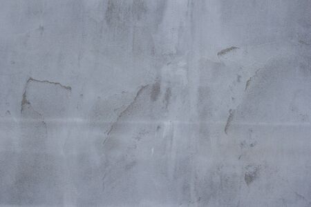 Gray concrete wall texture with scratches and cracks on it.の写真素材