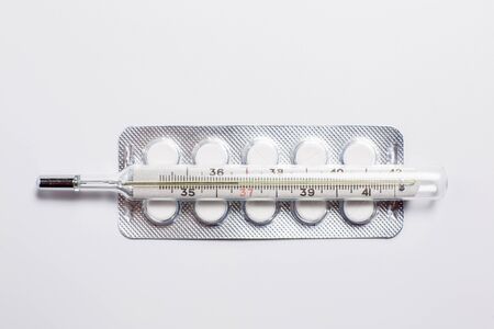 Pills for various diseases and a thermometer for measuring body temperatureの写真素材