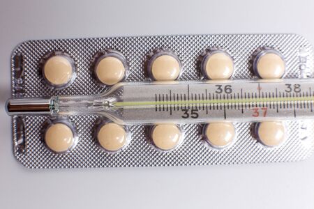 Pills for various diseases and a thermometer for measuring body temperatureの写真素材