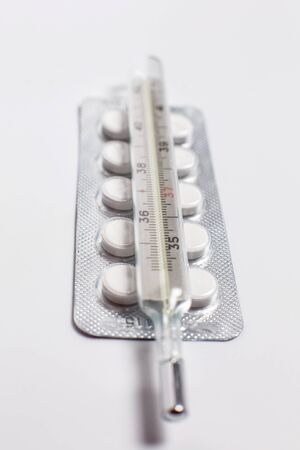 Pills for various diseases and a thermometer for measuring body temperatureの写真素材