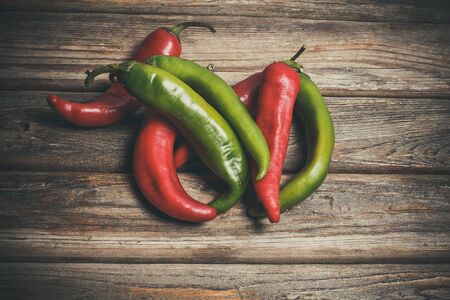 Hot peppers for spicy dishes on a wooden vintage table