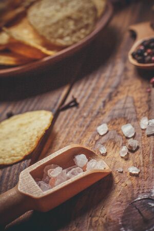 Chips with different spices on a wooden table in vintage style.の写真素材