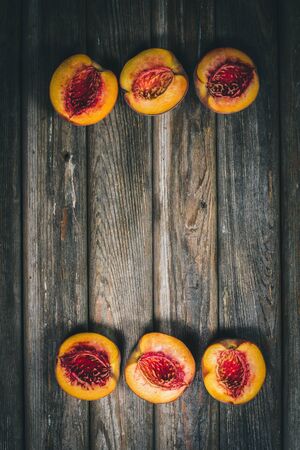 Ripe tasty peaches on a wooden brown surface in vintage style.の写真素材