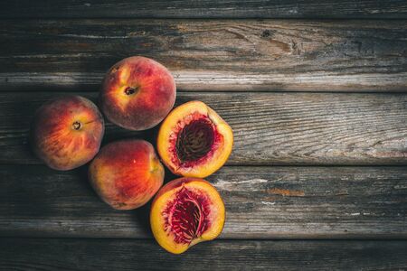 Ripe tasty peaches on a wooden brown surface in vintage style.の写真素材