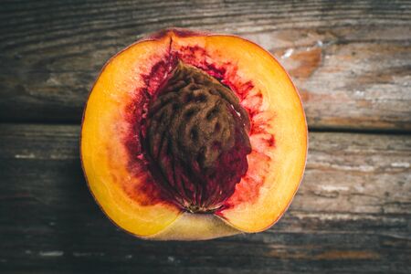 Ripe tasty peaches on a wooden brown surface in vintage style.