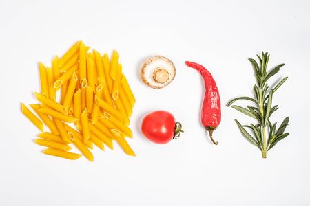 Raw pasta, fresh vegetables, tomatoes and mushrooms on a white backgroundの写真素材
