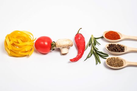 Raw tasty pasta with vegetables and spices on a white backgroundの写真素材