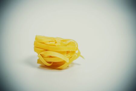 Raw delicious pasta for cooking on a white plate closeの写真素材