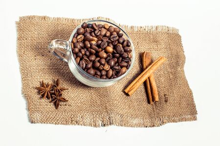 Cup with coffee grains, cinnamon on a white backgroundの写真素材