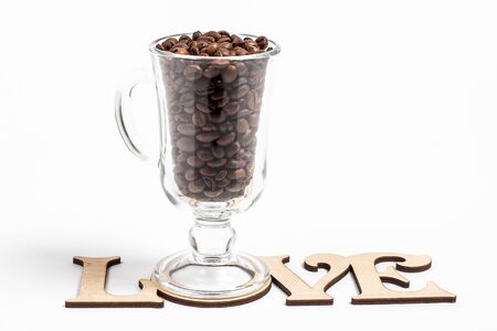 Glass of mulled wine and grains of coffee in it on a white background closeの写真素材