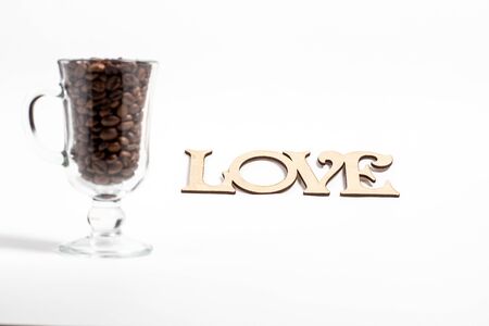 Glass of mulled wine and grains of coffee in it on a white background closeの写真素材
