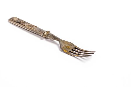 Antique metal rusty fork on a white background
