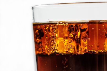 Black soda in a glass with ice on a white background closeの写真素材