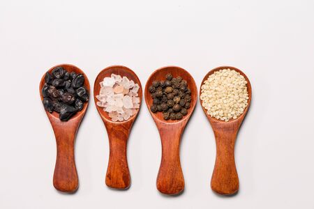 Spices and ingredients in wooden spoons on a white background