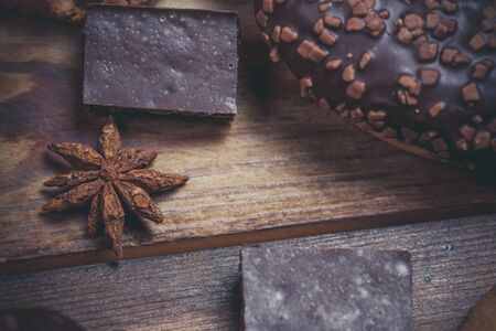 Chocolate donut and chocolate on a wooden table in warm color