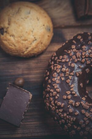 Chocolate donut and chocolate on a wooden table in warm colorの写真素材