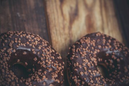 Chocolate donut and chocolate on a wooden table in warm colorの写真素材
