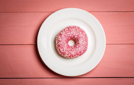 Tasty pink donut on a pink wooden backgroundの写真素材