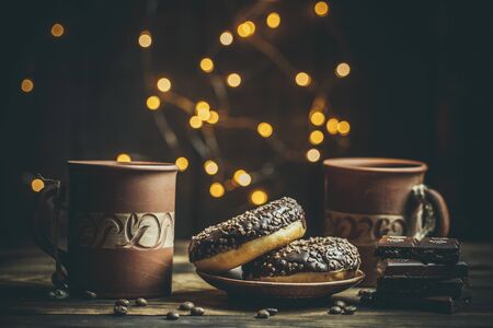 Delicious donuts with chocolate and a cup of coffee in warm colors.の写真素材