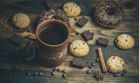Delicious donuts with chocolate and a cup of coffee in warm colors.の写真素材