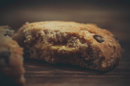 Cookies with chocolate and orange filling on a wooden surface