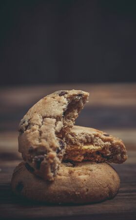 Cookies with chocolate and orange filling on a wooden surface
