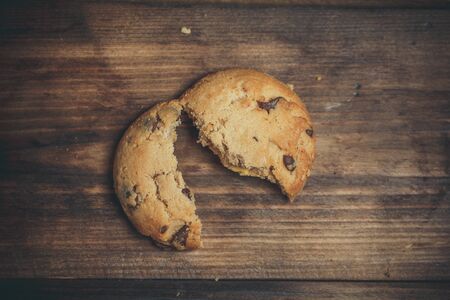Cookies with chocolate and orange filling on a wooden surfaceの写真素材