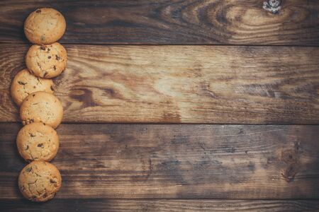 Cookies with chocolate and orange filling on a wooden surfaceの写真素材