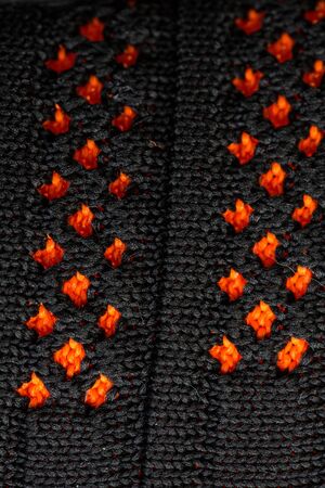 Black and orange fabric sewn together on shoes