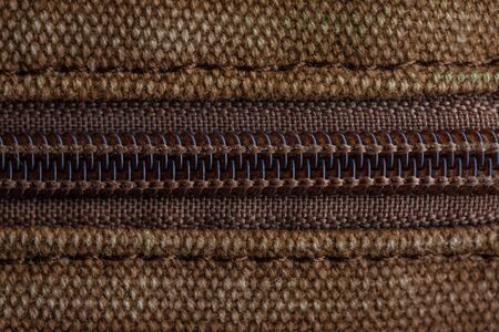 Thick khaki fabric and zipper on it in macroの写真素材
