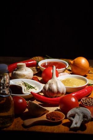 A lot of different spices, vegetables and ingredients for cooking on a wooden backgroundの写真素材