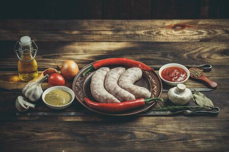 Many different spices, vegetables and ingredients, and fresh raw barbecue sausages for the family.の写真素材