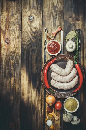 Many different spices, vegetables and ingredients, and fresh raw barbecue sausages for the family.の写真素材