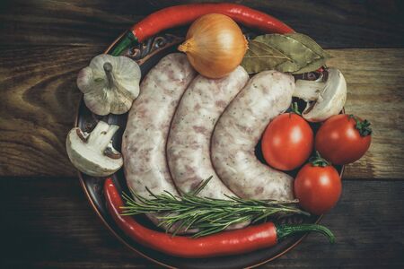 Many different spices, vegetables and ingredients, and fresh raw barbecue sausages for the family.の写真素材
