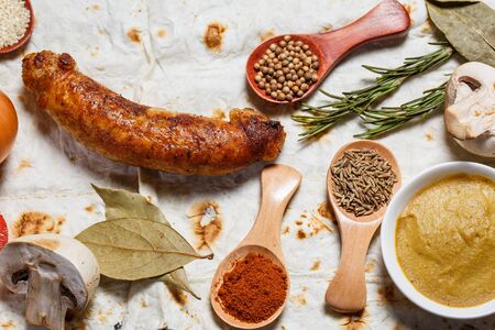 Fried sausages, vegetables, hot peppers and various spices and ingredients on pita breadの写真素材