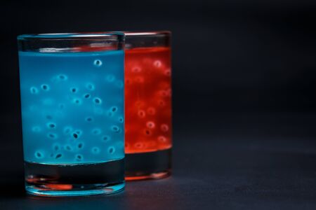 Red and blue cocktail on a black background
