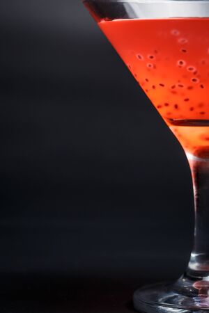 Tasty red cocktail with grains on a black backgroundの写真素材