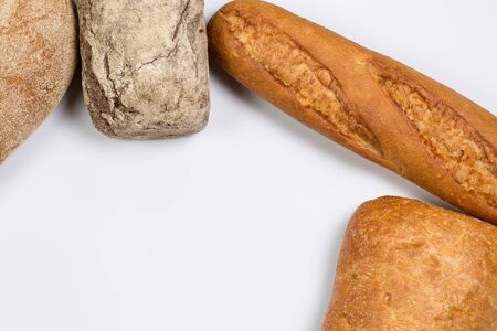 Tasty fresh black and white bread with wheat and flour on a white background