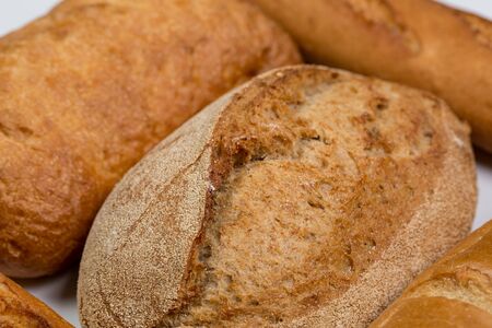 Tasty fresh black and white bread with wheat and flour on a white background