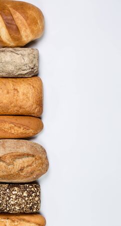 Tasty fresh black and white bread with wheat and flour on a white backgroundの写真素材
