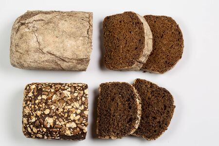 Tasty fresh black and white bread with wheat and flour on a white background