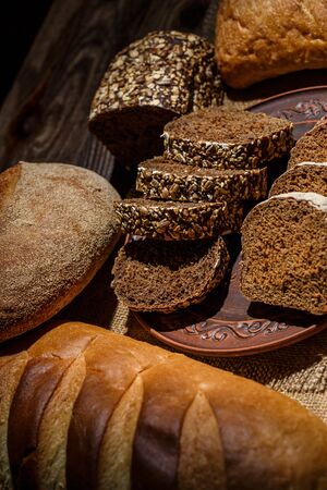 Fresh loaves of bread with wheat and gluten on a wooden table