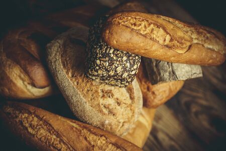 Different loaves of bread cooked with flour and gluten-free wheat on a wooden table