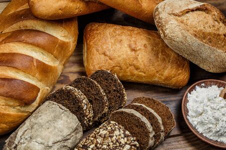 Different loaves of bread cooked with flour and gluten-free wheat on a wooden table