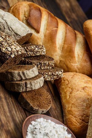Different loaves of bread cooked with flour and gluten-free wheat on a wooden table